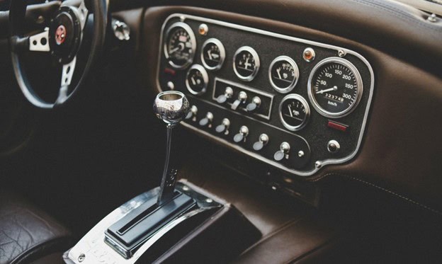 Classic car dashboard with manual gear shift and vintage gauges.