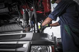 Technician repairing truck engine at Mason Truck Accessories service center.