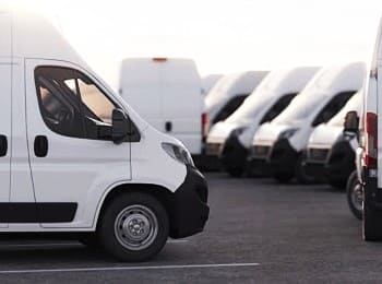Fleet of Mazda Pros Inc service vans parked outdoors.