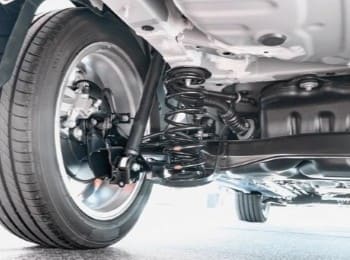 Suspension system of a Mazda vehicle with coil springs and shock absorbers.