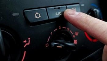 Technician adjusting car air conditioning system for optimal climate control.