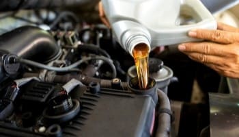 Engine oil being poured during vehicle service.