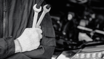 Skilled mechanic holding wrenches at Meineke Fresno car care center.