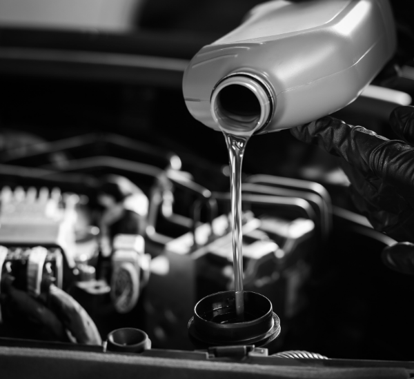 Pouring new oil into car engine during oil change service.
