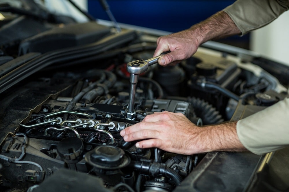 Car engine being serviced by mechanic for preventive maintenance.