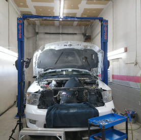 Car undergoing diagnostics and repair in a professional auto service shop.