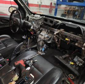 Damaged vehicle interior with exposed dashboard and wiring at Minotaur Mechanical.