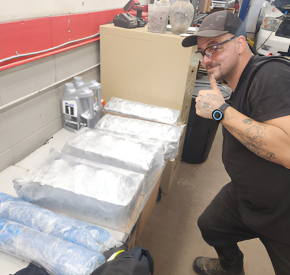 Technician at Minotaur Mechanical handling aluminum materials in workshop.