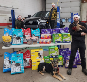 Minotaur Mechanical team showcasing pet food and supplies in garage setting.