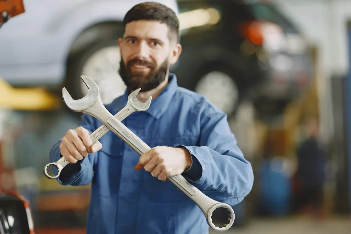 Skilled mechanic holding wrenches at Minotaur Mechanical auto repair shop.
