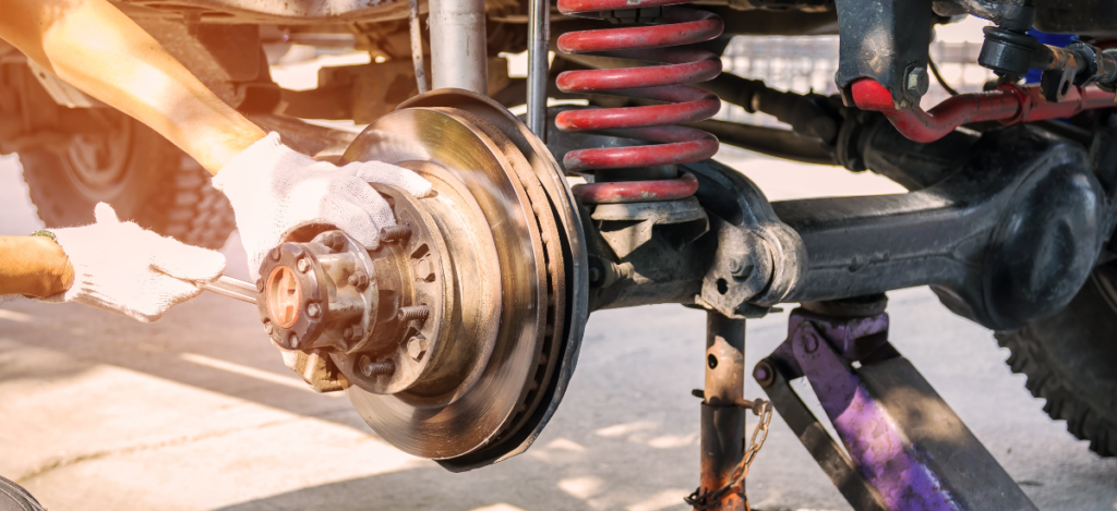 Skilled technician repairing vehicle suspension system at MJZ Garage auto repair shop.