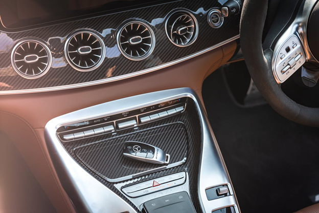 Luxury car interior with carbon fiber accents and advanced climate controls.