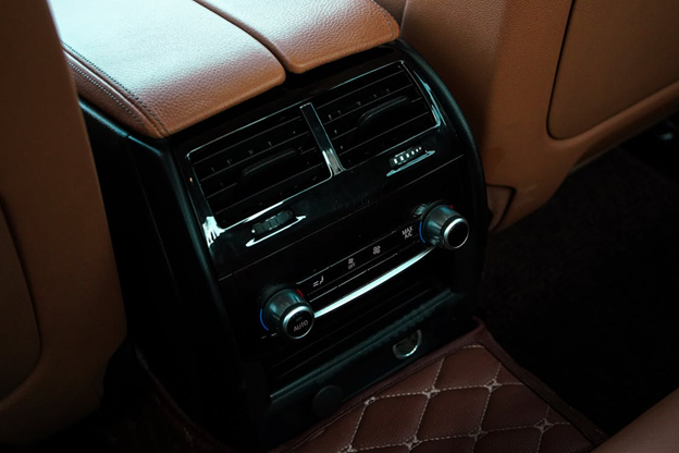 Interior car air vents and climate control panel in a luxury vehicle.