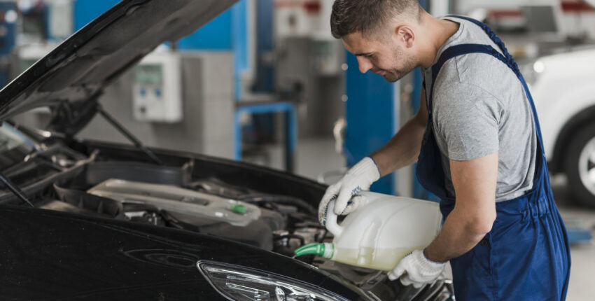 Auto mechanic inspecting engine at MJZ Garage, professional car repair services.
