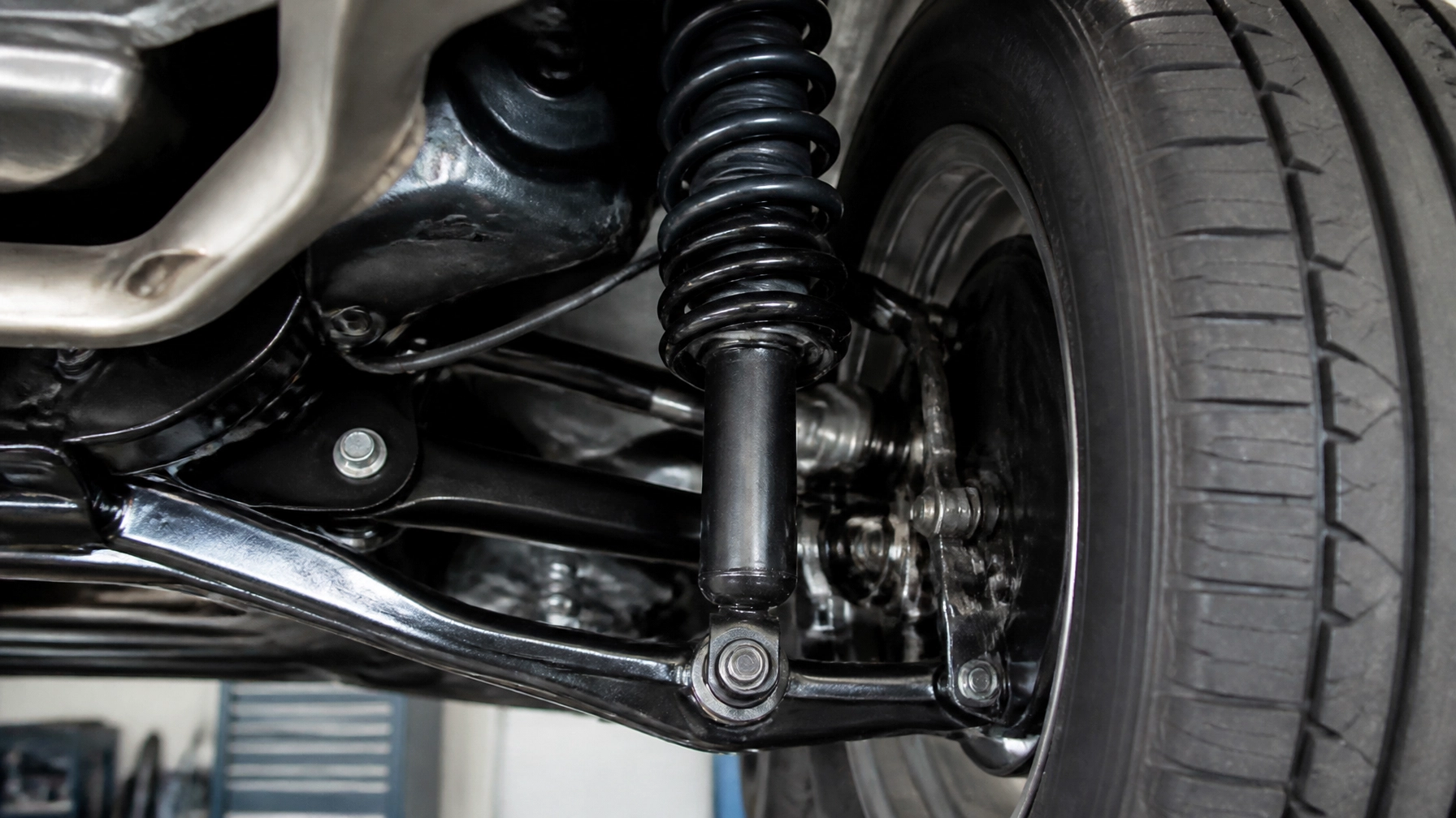 Close-up of car suspension and wheel at MNS Auto Services.