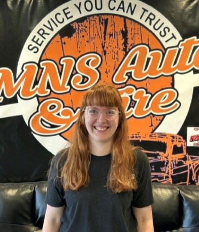 Smiling woman with red hair at MNS Auto Services.