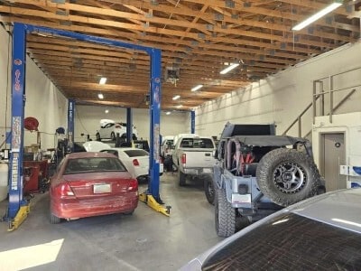 Auto repair shop with multiple vehicles on lifts and service bays.