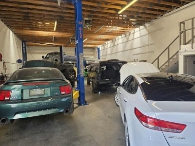 Auto repair shop with multiple cars on lifts and in service bays.