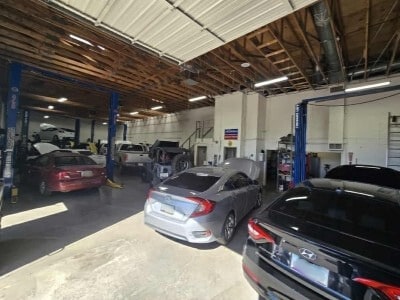 Auto repair shop with multiple vehicles on lifts and in service bays.