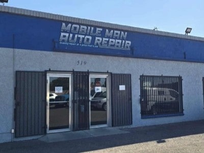 Auto repair shop storefront with signage and parking area.
