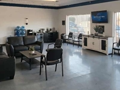 Auto repair shop waiting area with seating and TV.