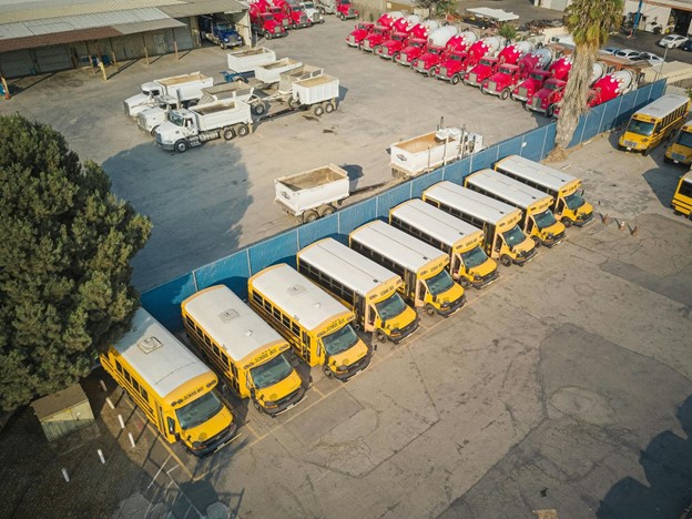 School buses lined up in a lot, ready for fleet maintenance and service.