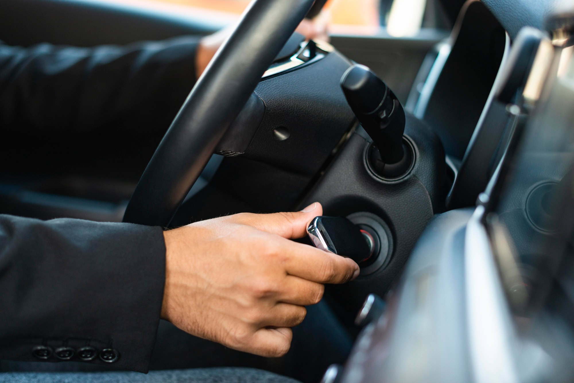 A person turning his car on with the help of ignition system