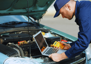 Technician using diagnostic tools on car engine at Motor Solution.