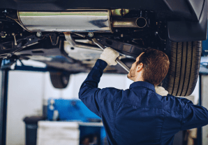 Skilled mechanic inspecting vehicle undercarriage at Motor Solution.