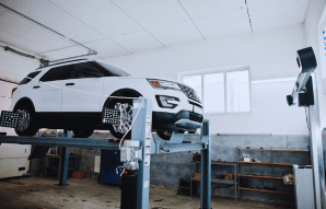 Modern car on diagnostic lift at Motor Solution workshop.