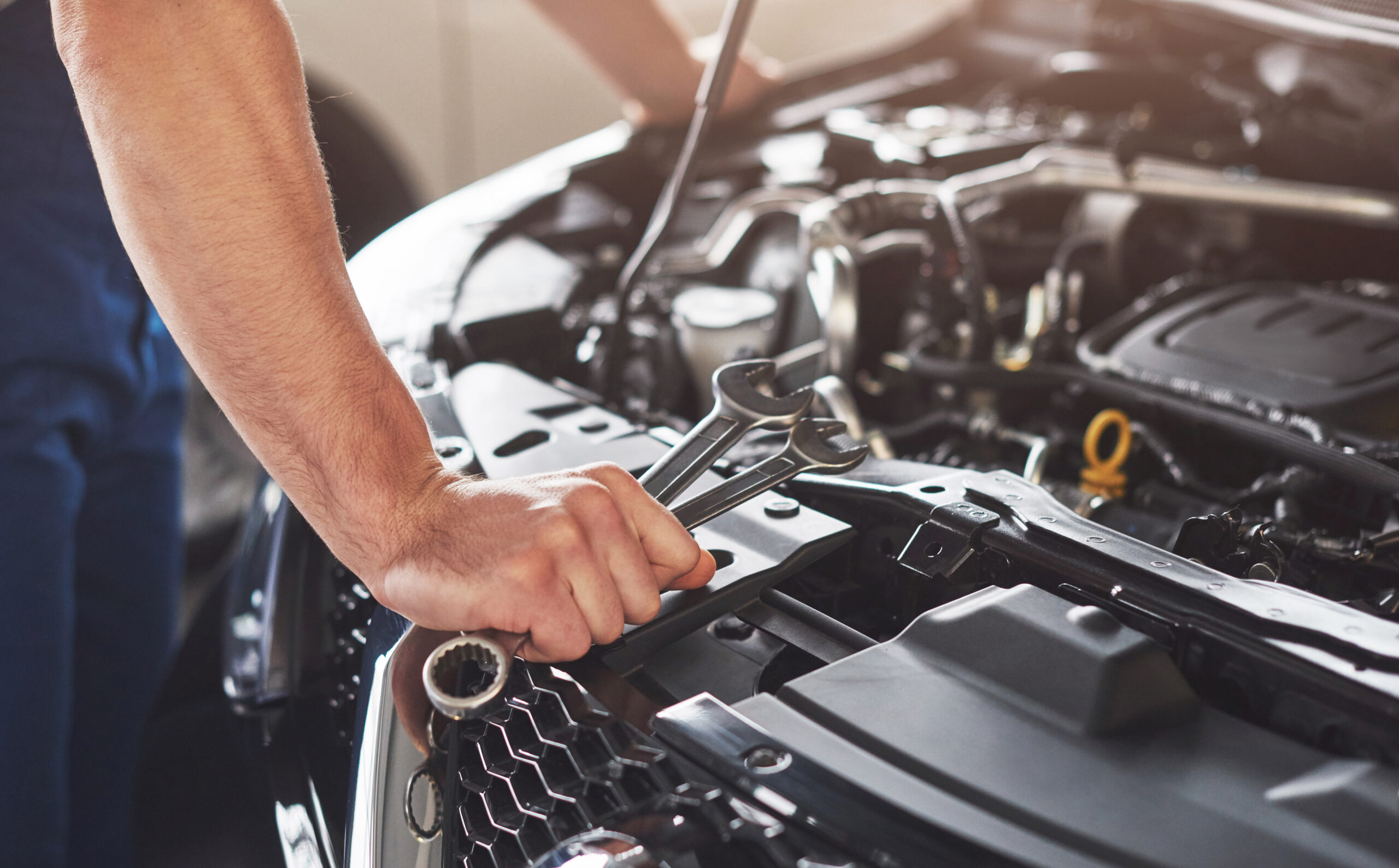 Automotive technician inspecting engine with diagnostic tools for check engine light issues.