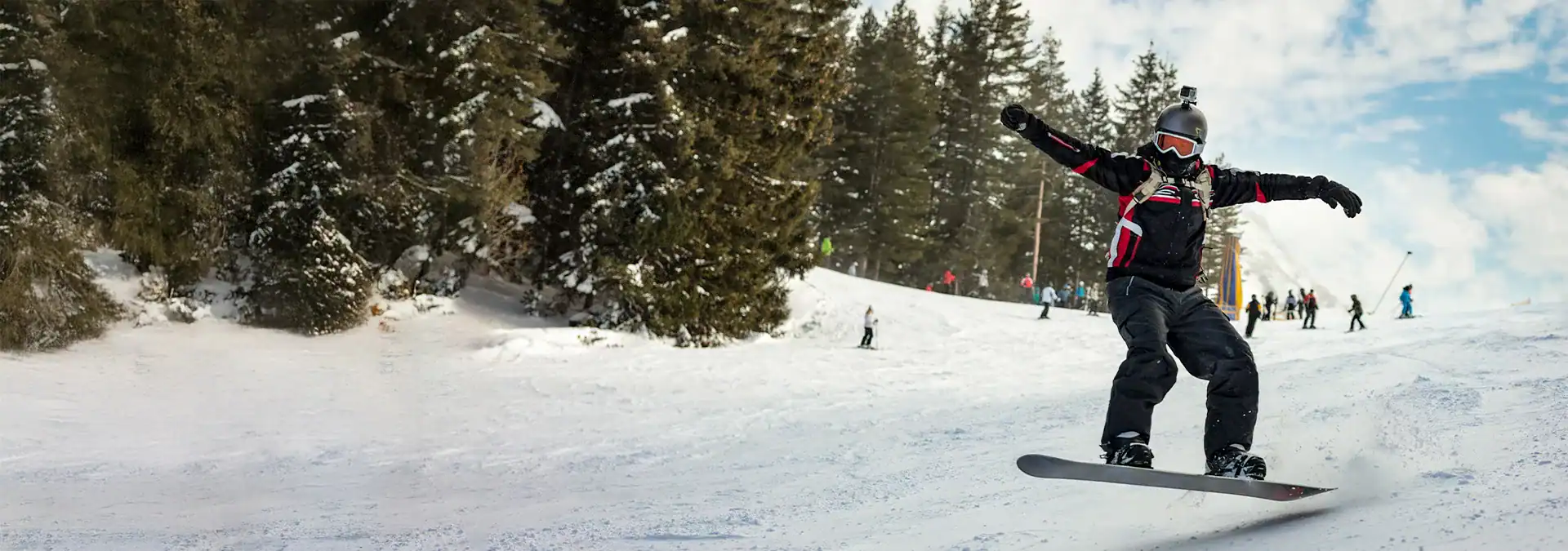 Snowboarding in winter sports mountain with skiers and pine trees, outdoor adventure and recreation.