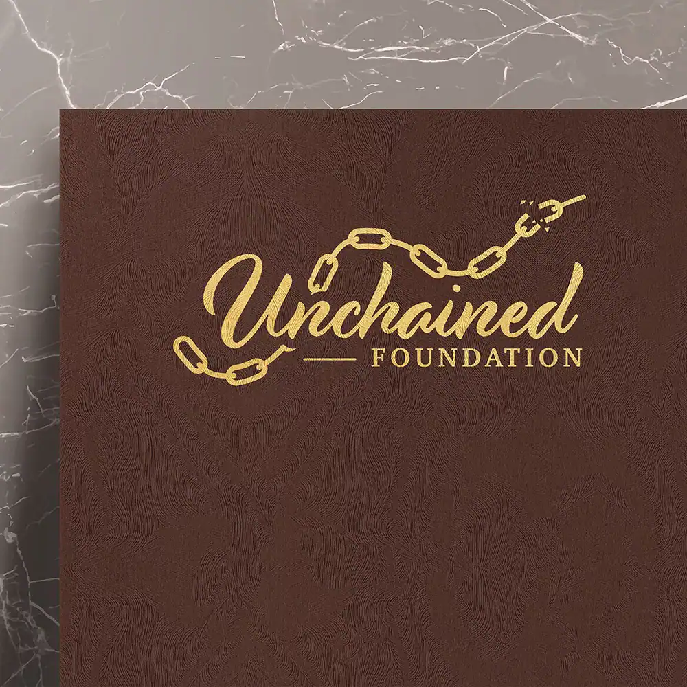 Unchained Foundation logo on brown textured background, branding for charitable organization.