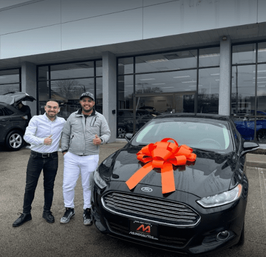 New Ford car with a red ribbon, celebrating a recent purchase at Mundo Auto Repair.