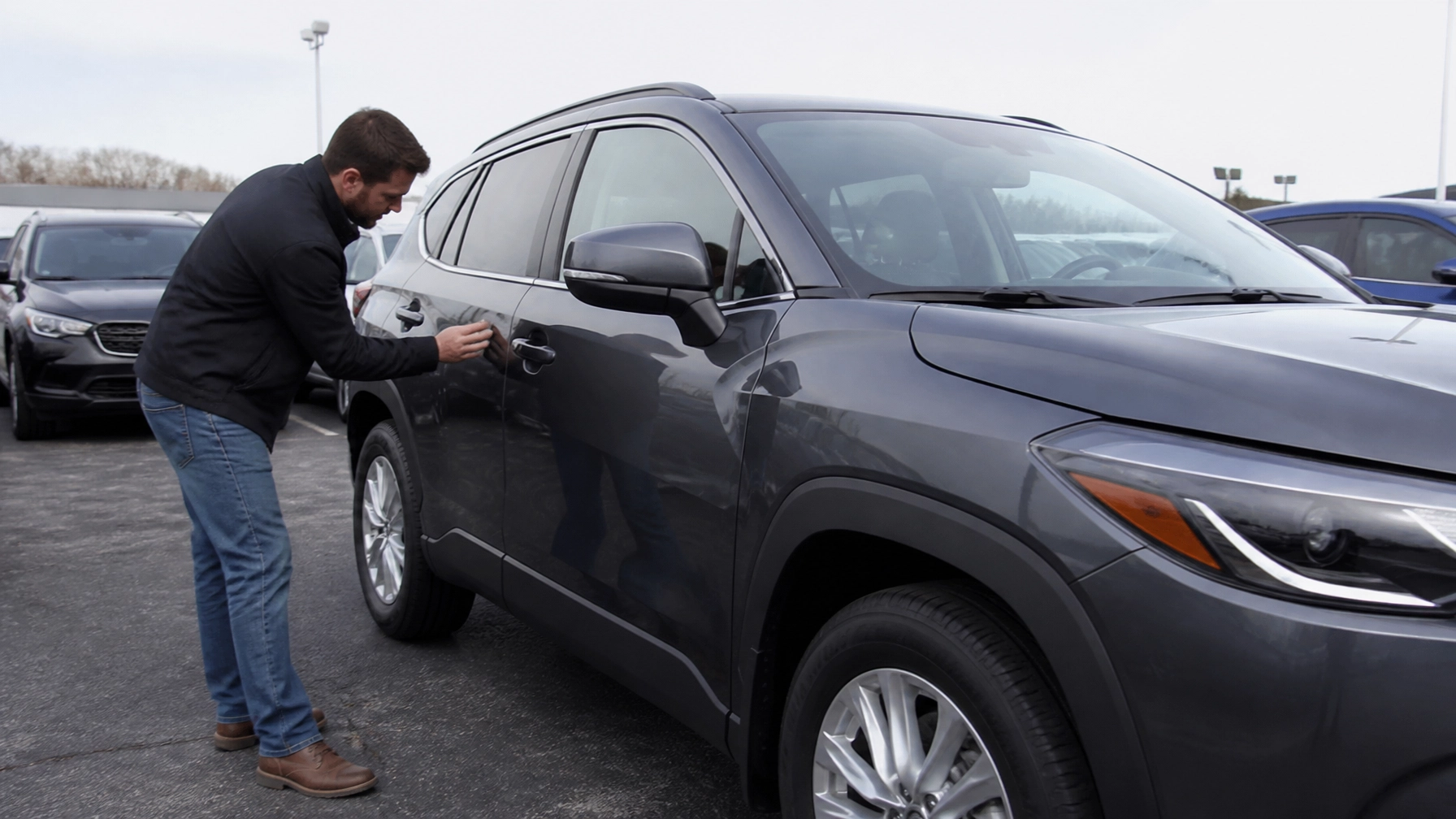 Man inspecting the exterior of a used SUV on a car lot