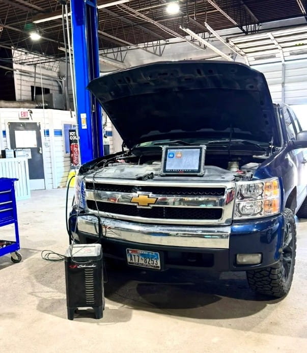 Chevrolet truck with open hood at Murdock & Son Automotive repair shop.