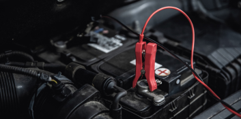 Jump start cables connected to car battery for emergency power.
