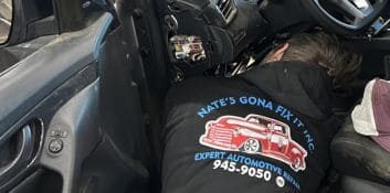 Technician repairing vehicle inside the car for auto repair services.