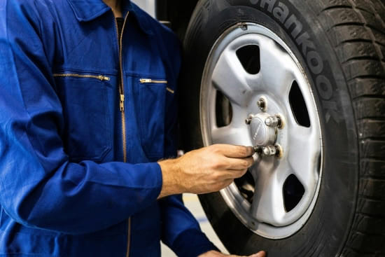 Technician changing a car tire at Nathan's Garage Ltd.