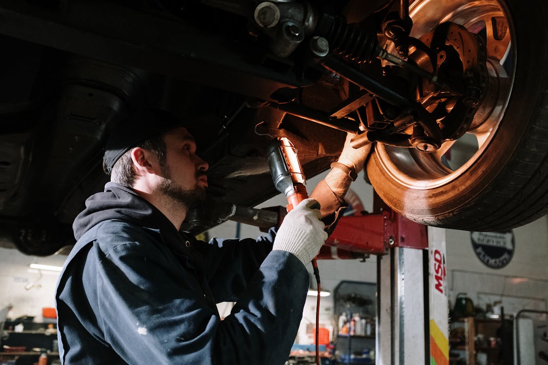 Skilled technician performing mechanical repairs on a car