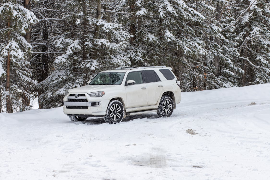 Auto repair vehicle in snowy landscape, emphasizing winter tune-up importance.
