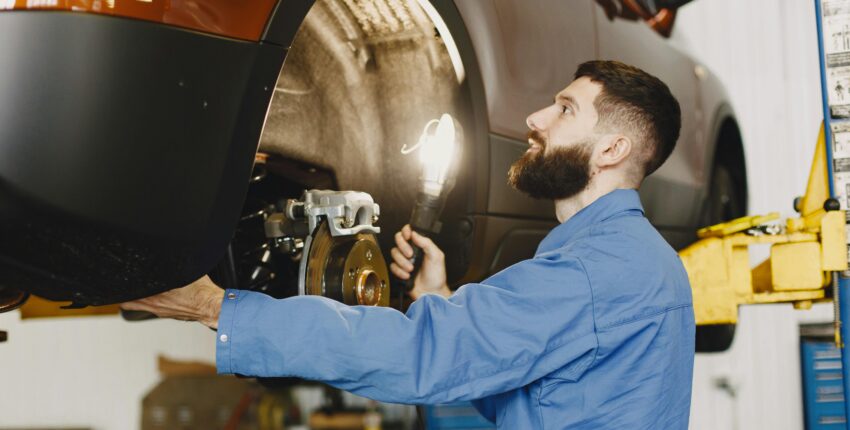 Technician inspecting car brakes during spring brake check in Mississauga.