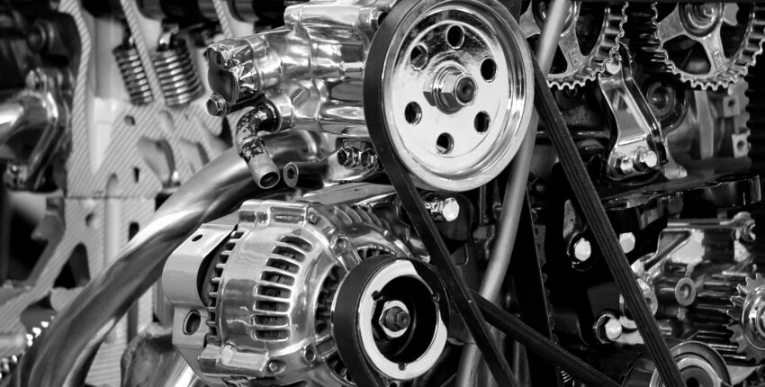 Close-up of engine timing belt and pulleys in a car engine.