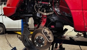 High-performance brake system installation on a red vehicle.