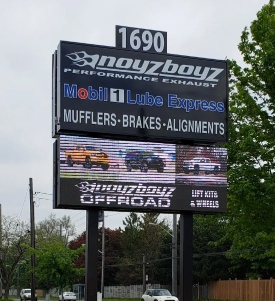 Performance exhaust and auto parts store sign in outdoor setting.