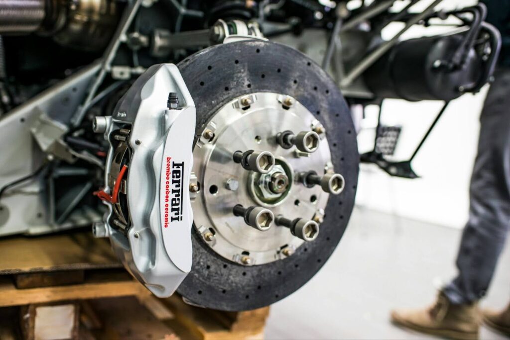 Close-up of a car brake rotor and caliper during repair at auto shop.