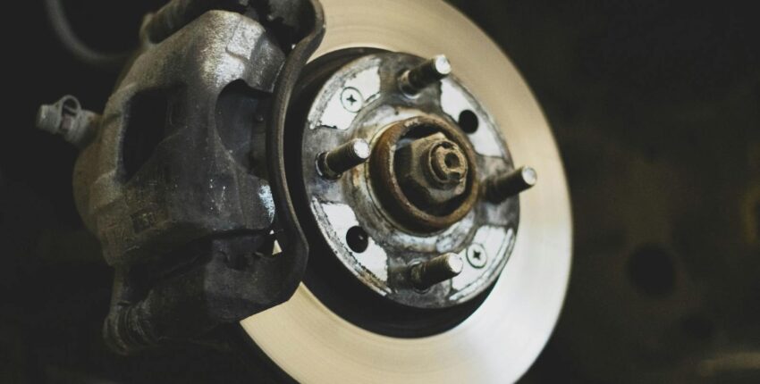 Close-up of a car brake rotor and caliper for brake replacement service.