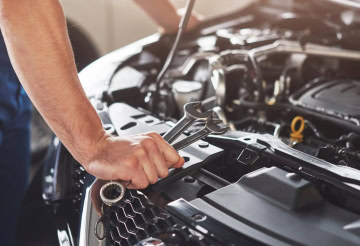 Car engine being serviced with tools at One Stop Auto Care.