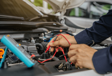 Automotive engine technician performing diagnostics under the hood.