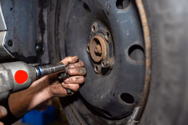 Mechanic replacing bolts on a car wheel during maintenance